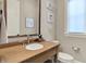Well-lit powder room featuring a wood vanity, modern faucet, and stylish decor at 12839 Bird Cage, Carmel, IN 46032