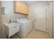 This laundry room has upper cabinets, utility sink, washer, dryer, and tile flooring at 12880 Oxbridge Pl, Fishers, IN 46037