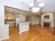 Open floor plan view of the kitchen, living, and dining areas with hardwood floors at 12880 Oxbridge Pl, Fishers, IN 46037
