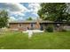 Backyard showcasing well-maintained lawn, wooden deck, grill, and screened-in porch for outdoor living at 13 Fairlane Dr, Brownsburg, IN 46112