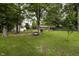Expansive backyard with lush green lawn, mature trees, and a charming swing set for outdoor fun at 13 Fairlane Dr, Brownsburg, IN 46112