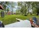 Spacious backyard featuring a deck with outdoor seating, lush lawn, trees, and swing set at 13 Fairlane Dr, Brownsburg, IN 46112