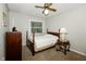 A cozy bedroom includes a bed, a dresser, an end table and a ceiling fan at 13 Fairlane Dr, Brownsburg, IN 46112