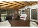 This screened porch boasts wood floors, wicker furniture, and a view of the backyard at 13 Fairlane Dr, Brownsburg, IN 46112