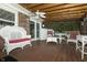 Screened porch with wooden floor and ceiling featuring wicker furniture for relaxed outdoor living at 13 Fairlane Dr, Brownsburg, IN 46112