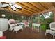 Relaxing screened porch with wicker furniture, wood paneled ceiling and serene outdoor view at 13 Fairlane Dr, Brownsburg, IN 46112