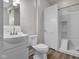 Bathroom featuring a white sink and vanity, toilet, and shower-tub combo with white tiled surround at 1310 California St, Columbus, IN 47201