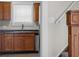 View of kitchen sink and dark countertops with view of carpeted stairs at 1310 California St, Columbus, IN 47201