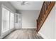 Living room featuring wood-look flooring, windows, and a staircase with wood handrail at 1310 California St, Columbus, IN 47201