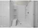 Spacious walk-in shower with built-in bench and shelves, enclosed by a white door at 1310 California St, Columbus, IN 47201