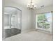 Elegant dining room featuring a chandelier, a large window, and access to the hallway at 13355 Freenza Ct, Carmel, IN 46074