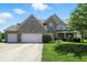 Charming two-story brick home with a three-car garage and manicured front lawn at 13355 Freenza Ct, Carmel, IN 46074