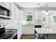 Bright kitchen featuring white cabinets, stainless steel appliances, and granite countertops at 13355 Freenza Ct, Carmel, IN 46074