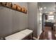 Welcoming hallway featuring dark hardwood floors, a coat rack, and an entry bench at 13992 Wynngate Ln, Fishers, IN 46038