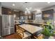 Modern kitchen featuring dark cabinets, granite countertops, stainless steel appliances and a center island at 13992 Wynngate Ln, Fishers, IN 46038