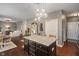 Open-concept kitchen with a granite island, dark cabinets, dining area, and a view into the living room at 13992 Wynngate Ln, Fishers, IN 46038