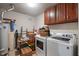 Functional laundry room with washer, dryer, storage cabinets, and ample space for sorting and folding at 13992 Wynngate Ln, Fishers, IN 46038