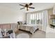 Cozy bedroom with a crib, bed, chair, and bright window, perfect for relaxing or enjoying the outdoors at 14682 Braemar E Ave, Noblesville, IN 46062