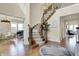 Bright open foyer with hardwood floors, elegant staircase, and views into adjacent living spaces at 14682 Braemar E Ave, Noblesville, IN 46062