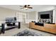 Comfortable living room area with a desk and tan leather sofa under a ceiling fan and plush carpeting at 14682 Braemar E Ave, Noblesville, IN 46062