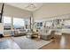 Bright living room with large windows, hardwood floors, and an open layout to the modern kitchen at 14682 Braemar E Ave, Noblesville, IN 46062