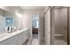 Contemporary bathroom with a dual sink vanity, large mirror, shower room, and view to a bedroom at 17303 Lillian St, Westfield, IN 46074