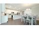 Open-concept kitchen with stainless steel appliances, white cabinets, island, and adjacent dining area for modern living at 17303 Lillian St, Westfield, IN 46074