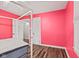 Inviting bedroom features pink walls, wood floors, and a door to the ensuite bathroom at 1739 Caldwell Pl, Columbus, IN 47201