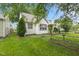 View of the house with vibrant green lawn, mature trees, and manicured landscaping at 1739 Caldwell Pl, Columbus, IN 47201