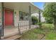 Cozy porch with decorative iron railings, a bright red door, and manicured landscaping at 1739 Caldwell Pl, Columbus, IN 47201