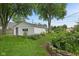 Detached garage surrounded by lush greenery, vibrant flowers, and stone accents at 1739 Caldwell Pl, Columbus, IN 47201