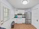 Well-lit kitchen featuring white cabinets, stainless-steel refrigerator and terracotta-colored tiled floor at 1739 Caldwell Pl, Columbus, IN 47201