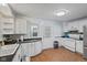 Bright kitchen showcases white cabinets, black counters, tiled backsplash, and door leading to outside at 1739 Caldwell Pl, Columbus, IN 47201