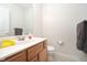 Half bath with a wood vanity, white countertop, decorative mirror, and convenient toilet at 18432 Oriental Oak Ct, Noblesville, IN 46062