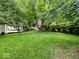 Large backyard surrounded by mature trees offering plenty of space at 228 W Washington St, Shelbyville, IN 46176