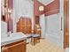 Retro bathroom features red patterned wallpaper, classic fixtures, and a shower with white tile surround at 228 W Washington St, Shelbyville, IN 46176