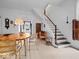 Dining room area boasts a round table, staircase, and neutral tones, creating a welcoming and classic aesthetic at 228 W Washington St, Shelbyville, IN 46176