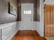 Entryway features hardwood floors, contrasting wallpaper, and paneled trim for a vintage touch at 228 W Washington St, Shelbyville, IN 46176