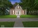 Charming two-story home with red shutters, pristine lawn, and inviting walkway to the front door at 228 W Washington St, Shelbyville, IN 46176