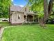 Charming home with a covered porch, surrounded by lush greenery, offering a cozy outdoor retreat at 228 W Washington St, Shelbyville, IN 46176