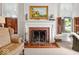Living room with a decorative fireplace, detailed mantel, and adjacent windows at 228 W Washington St, Shelbyville, IN 46176