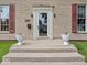 Close-up of front door with decorative planters, and a welcome entrance to this charming home at 228 W Washington St, Shelbyville, IN 46176