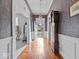 Hallway showcasing hardwood floors, vintage wallpaper and an antique grandfather clock at 228 W Washington St, Shelbyville, IN 46176