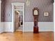 The hallway features hardwood flooring, decorative wallpaper, and a tall clock to create a vintage aesthetic at 228 W Washington St, Shelbyville, IN 46176