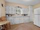Vintage kitchen featuring classic white cabinets, countertops, and a window, combining function and nostalgia at 228 W Washington St, Shelbyville, IN 46176