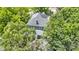 Aerial view of charming home surrounded by lush greenery, with a welcoming porch and mature trees in a desirable neighborhood at 23 S Downey Ave, Indianapolis, IN 46219