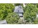 Aerial view showcases a gray-roofed house surrounded by mature trees, offering privacy and charm at 23 S Downey Ave, Indianapolis, IN 46219