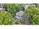 Aerial view showcases a charming two-story home with a cozy front porch, surrounded by lush greenery and mature trees at 23 S Downey Ave, Indianapolis, IN 46219