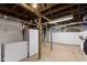 Functional basement space with exposed ceiling, appliances, and storage at 23 S Downey Ave, Indianapolis, IN 46219