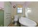 Quaint bathroom features a clawfoot tub, pastel walls, and built-in storage at 23 S Downey Ave, Indianapolis, IN 46219